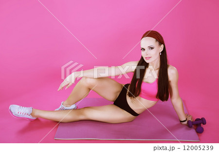 Recreation. Athletic Sporty Woman Resting on a Pink Rug 12005239