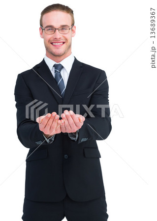 Smiling businessman holding out his hands 13689367