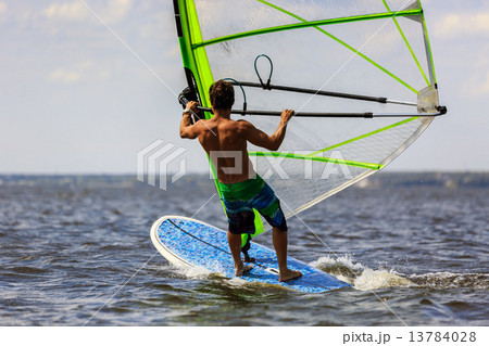 Rear view of young windsurfer 13784028