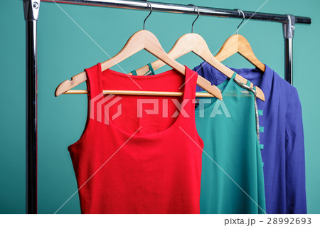 colorful women's shirts on wood hangers on blue 28992693