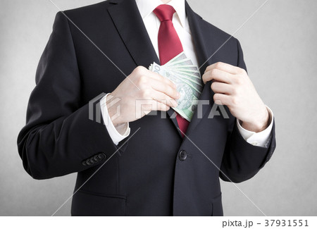 Man putting polish money in suit jacket pocket.  37931551