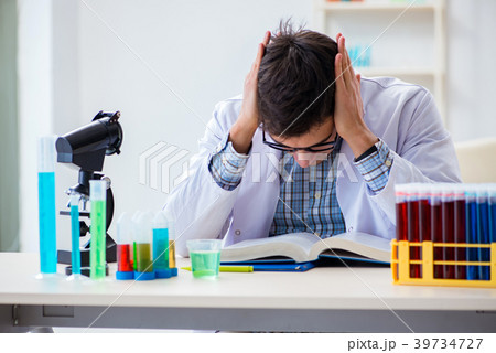 Young chemist student working in lab on chemicals 39734727