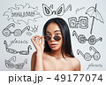 Fashion look. Portrait of attractive asian woman adjusting her sunglasses and looking at camera 49177074