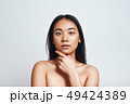 Perfect skin. Portrait of beautiful asian woman touching her skin and looking at camera while 49424389