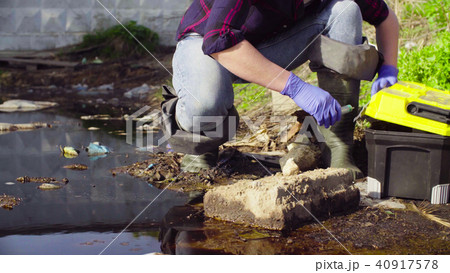 Hands of ecologist taking samples of the water. 40917578