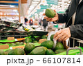 Closeup women's hands hold groceries in the store. The concept of buying fruits and vegetables in a hypermarket during quarantine 66107814