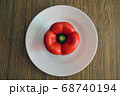 Red bell pepper on white food plate on wooden 68740194