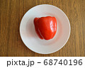 Red bell pepper on white food plate on wooden 68740196