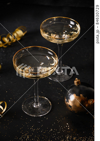 New Year champagne glasses and Christmas gold decorations on black background. 84630729