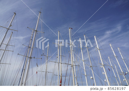 several sail boat masts against blue sky 85628197