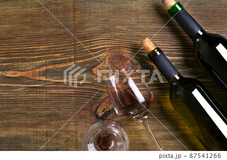 Bottles and two glasses of wine on wooden background from top view 87541266