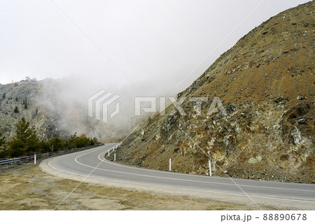 mountain landscape with a dangerous road bend in the fog 88890678