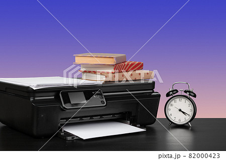 Home laser printer on desk against purple background 82000423