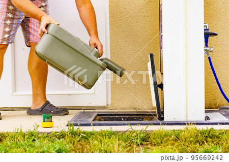 Man emptying caravan tank toilet cassette in dump station. 95669242