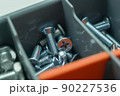 New metal screws for connecting parts. Fasteners in a tool box. Little cogs. Selective focus 90227536