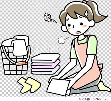 A young woman folding laundry with a tired expression 92631170