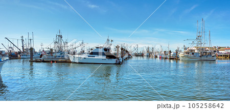 Small fishing trawler and yachts moored at the ocean pier 105258642