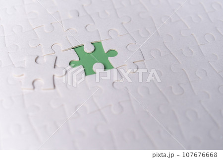 Puzzle pieces on green background.white jigsaw puzzle pieces copy space for text, top view. 107676668