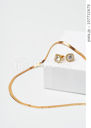 Golden diamond neacklace and earrings on white background 107732678