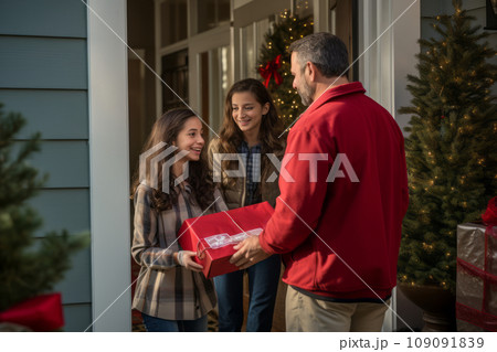 A family receiving a holiday delivery at their doorstep, with the delivery person , portraying the convenience of home deliveries during the season. 109091839