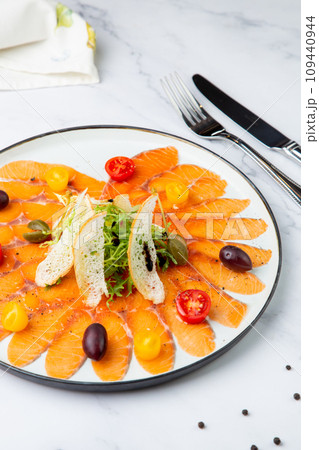 Sliced red fish slices with herbs, cherry tomatoes and white bread croutons 109440944