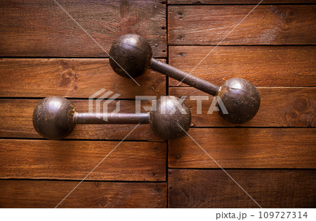 Old rusty dumbbells on wood background texture 109727314