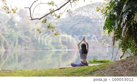 Asian woman doing yoga in nature in the forest, Meditation and breathing exercises, Treat ADHD and train your mind to be calm, Healthy exercise, Mindfulness, Homeopathy, Park yoga. 100053012