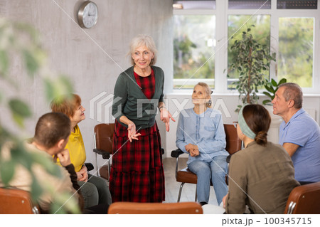 Woman psychologist attentively listens to the stories of adults in group therapy 100345715