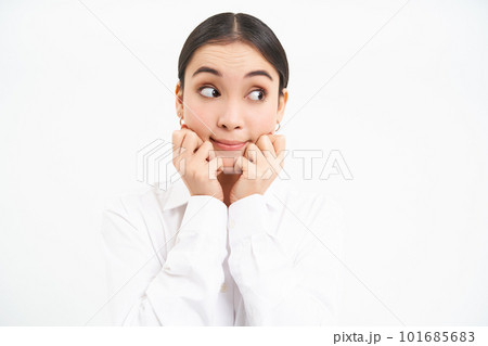 Cute korean woman looks with excitement to the right, sees something tasty, stands over white background 101685683