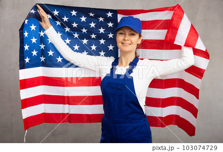 Smiling adult woman in uniform holding USA flag 103074729