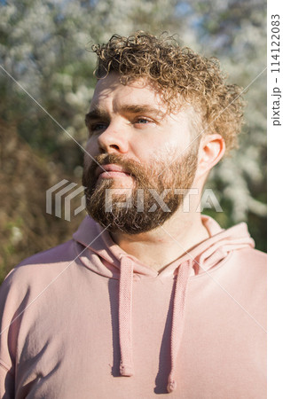 Man with beard and mustache near sakura flowers or blooming spring tree. Soft and gentle concept. Bearded man with stylish haircut with flowers on background, close up. Hipster near branch of bloom 114122083