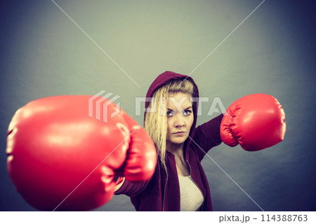 Woman wearing boxing gloves 114388763