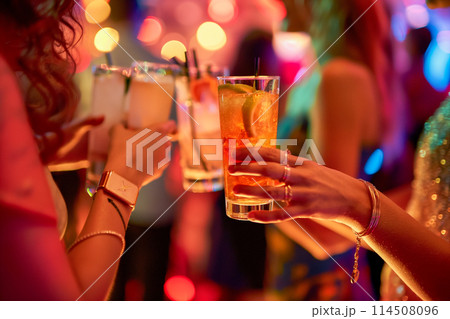 A group of people are holding up their drinks and smiling at the camera 114508096