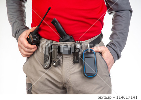 walkie-talkie, flashlight, knife, GPS navigator on the belt of the tourist trekking pants 114617141