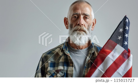 Portrait of older man holding American flag. Symbolizes patriotism and respect for veterans. 115015727