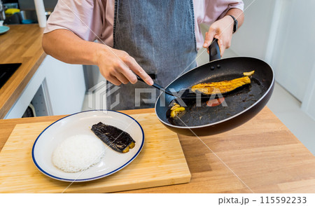 Chef at the kitchen preparing grilled eggplants with garlic 115592233