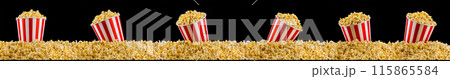 Scattered popcorn from paper striped bucket isolated on black background 115865584