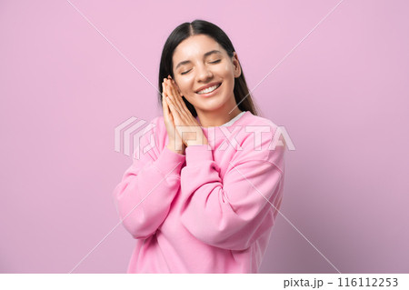 Dreamy vibes. Young woman in pink, eyes closed, smiling like she's in a sweet daydream. Perfect for capturing peaceful, blissed-out moments. Pure zen and happiness 116112253