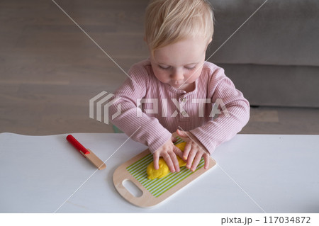 smiling little toddler working with plasticine in art and craft  117034872