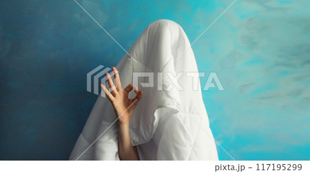 Cheerful lazy woman waking up after sleeping covered head with white blanket showing ok gesture 117195299