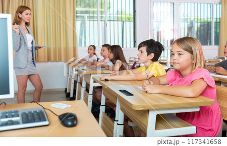 Group of school kids and teacher during lesson in classroom 117341658