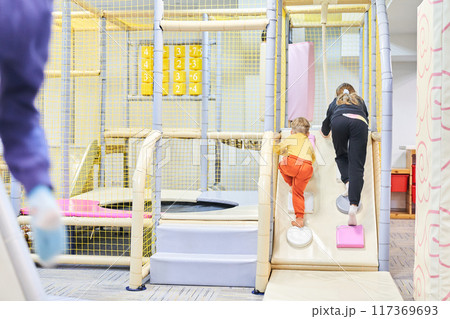 Unrecognizable children play in the indoor entertainment center. Active recreation for children, in the sports center. Entertainment park. With space to copy. High quality photo 117369693