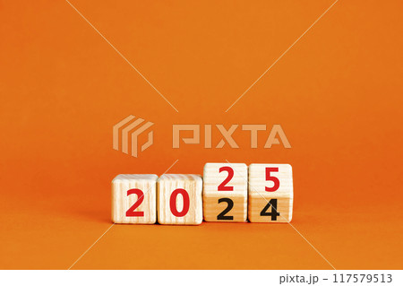 Business concept of 2025 new year symbol. Beautiful turned wooden cube and changed number 2024 to 2025. Beautiful orange table orange background, copy space. Business 2025 happy new year concept. 117579513