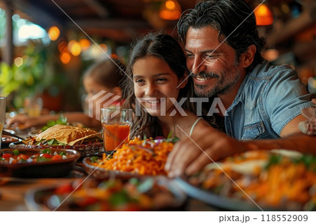 A family enjoying a meal of Mexican food including tortas and enchiladas 118552909