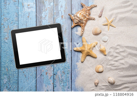 Summer, beach and vacation concept with free text space. Top view. Flat layout with a blank tablet, large sea star and sea shell and various sea shells and fine beach sand on an old blue wooden boards 118804916