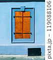 Old wooden window shutters on house with blue facade wall 119088106