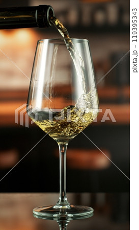 Pouring white wine from bottle. 119395343