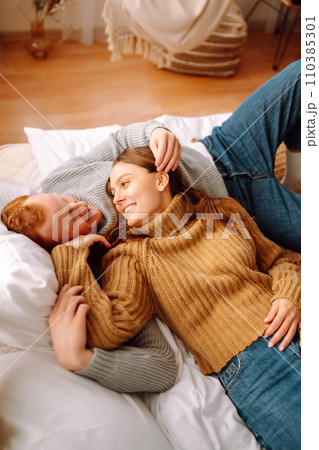 Couple in love relaxing at home on bed while they hug each other. Valentine's Day, holiday concept. 110385301