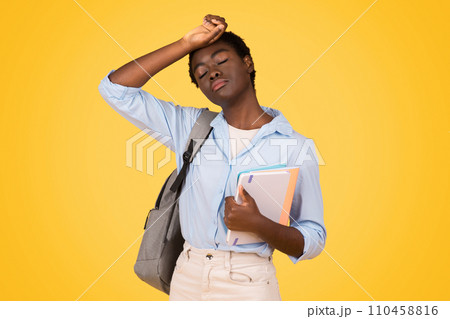 A black woman student, visibly tired and sweating, depicts exhaustion 110458816