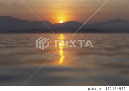 Beautiful morning scenery of River and mountain in a dramatic sky, the magic of sunset and sunrise, with a symphony of colors - orange, red, blue, and yellow, a colorful horizon of nature 111134985